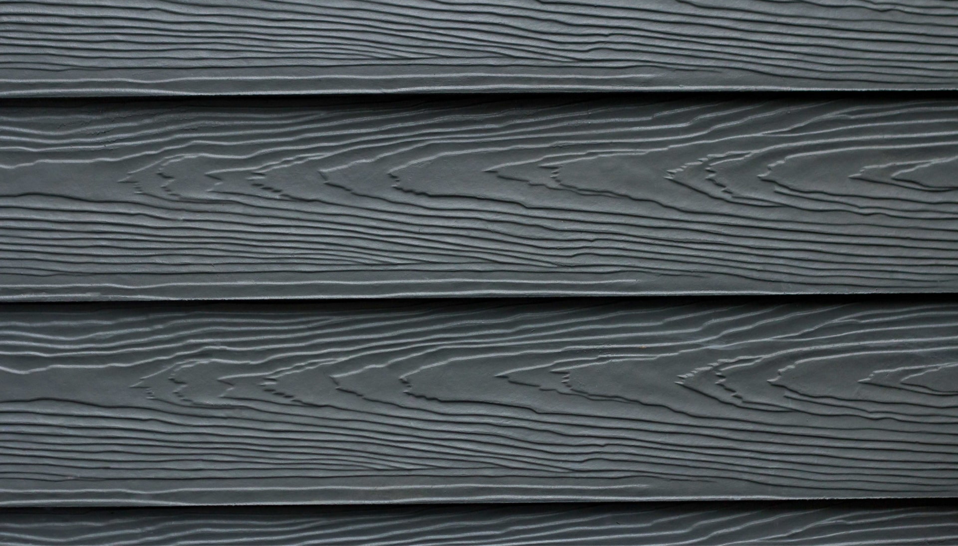 Beautiful grey fiber cement siding with natural looking wood grain installed on an older home.
